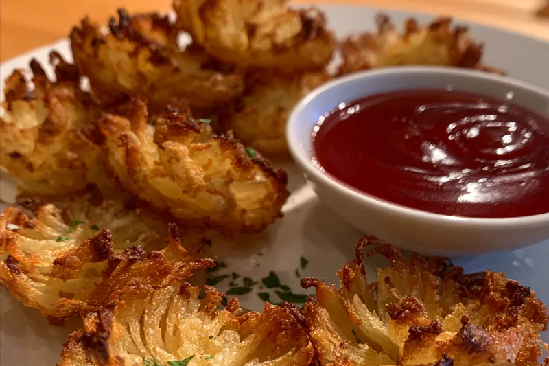 Fresh onions and spices laid out for crispy mini bloomin' onions preparation.