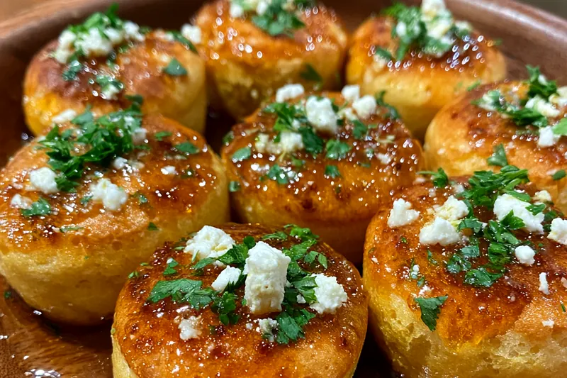 Golden Honey Cornbread Bites baking in the oven with a golden crust.