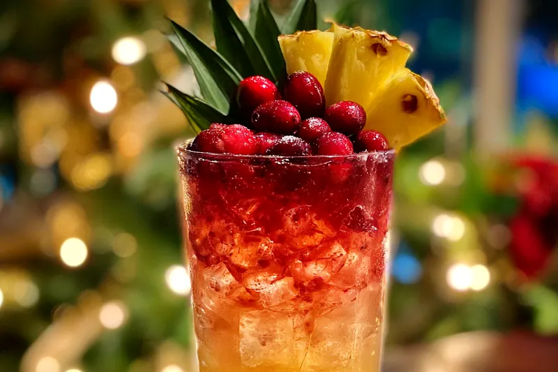 A vibrant assortment of fresh ingredients for the Festive Pineapple Cranberry Cocktail, including pineapple juice, cranberry juice, and fresh fruits.