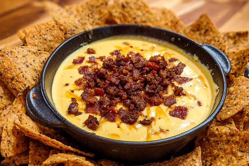 Ingredients laid out for Creamy Bacon Cheeseburger Dip including cream cheese, bacon, and spices.