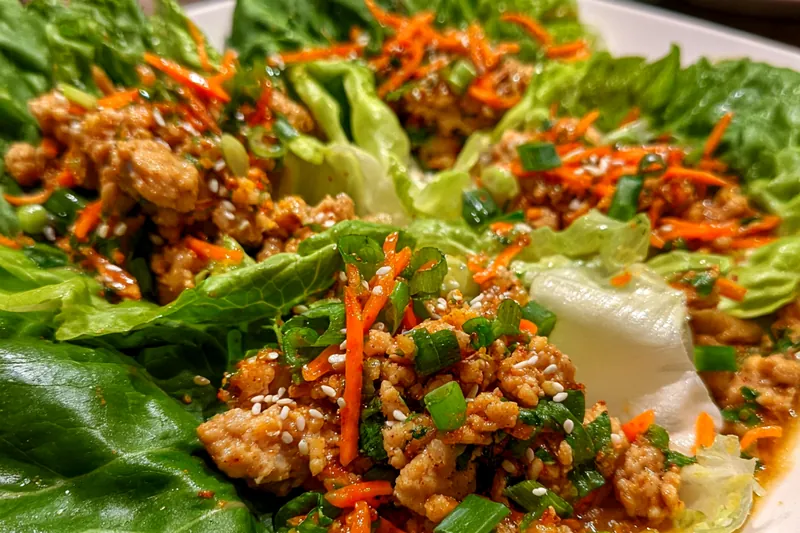 Ingredients for Zesty Thai Chicken Wraps laid out on a kitchen counter.